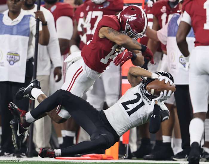 Cincinnati Bearcats receiver Tyler Scott (21) makes a reception against Alabama Crimson Tide cornerback Brian Branch (14) during the 2021 Cotton Bowl college football CFP national semifinal game at AT&T Stadium.